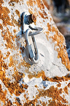 ÃÂ¡limbing carabiner hook and trigger device in stone. Carabiner for mountaineering on rocky background. photo